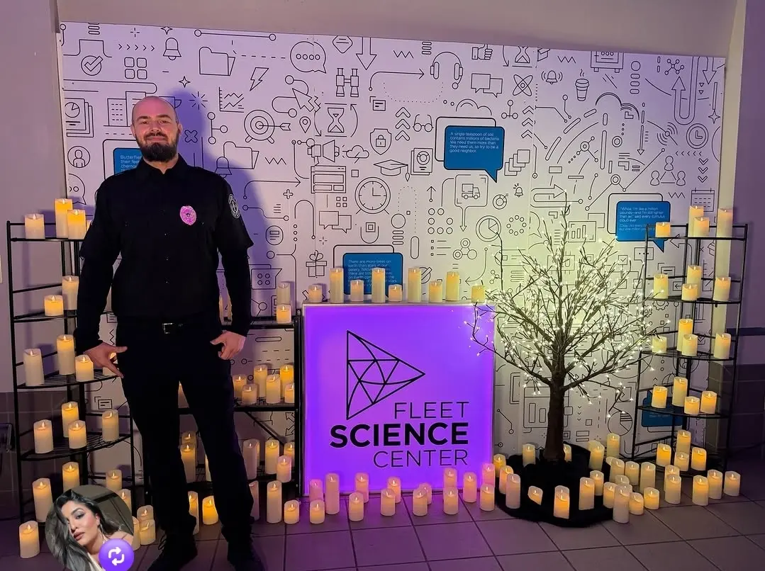 Security guard standing at a candlelight event setup at Fleet Science Center, ensuring event safety, crowd management, and professional security presence.